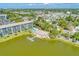 Aerial view of the condo community featuring lush landscaping, a pool, lake, and a fishing pier at 3562 Lake Bayshore Dr # 202, Bradenton, FL 34205