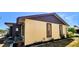 Side view of the house with a light yellow wall, brown trim, and an air conditioning unit at 3915 40Th W St, Bradenton, FL 34205