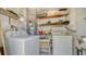 Functional laundry area with washer, dryer, shelving, and utility connections, maximizing space and efficiency at 4015 52Nd Street W Ct, Bradenton, FL 34209
