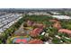 This aerial view showcases a community with mature trees, a lake and a tennis court at 4138 Central Sarasota Pkwy # 1524, Sarasota, FL 34238