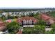 Beautiful condo building with a red tile roof, tennis courts, mature landscaping, and water views at 4138 Central Sarasota Pkwy # 1524, Sarasota, FL 34238
