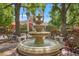 Beautiful three-tiered fountain on a bricked surface with benches under a canopy of shady trees at 4138 Central Sarasota Pkwy # 1524, Sarasota, FL 34238