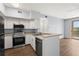 Charming kitchen featuring stainless steel appliances, breakfast bar, and wood flooring at 4138 Central Sarasota Pkwy # 1524, Sarasota, FL 34238