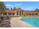 Exterior shot of community pool and clubhouse with tile roof and stately white columns at 4138 Central Sarasota Pkwy # 1524, Sarasota, FL 34238