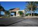 Exterior view of beach house with covered breezeway surrounded by palm trees at 4310 Falmouth Dr # 305, Longboat Key, FL 34228