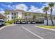 Low-rise apartment building with covered parking, professional landscaping and decorative palm trees at 4310 Falmouth Dr # 305, Longboat Key, FL 34228