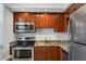 Modern kitchen features stainless steel appliances, wood cabinets, and stone countertops at 4310 Falmouth Dr # 305, Longboat Key, FL 34228