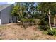 Backyard with a variety of plants and mature trees providing shade at 4639 Sloan Ave, Sarasota, FL 34233