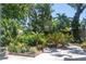 Seating area surrounded by greenery and landscaping in a serene backyard setting at 4639 Sloan Ave, Sarasota, FL 34233