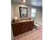 Bathroom vanity with granite countertop, sink, mirror, and tiled floor at 4639 Sloan Ave, Sarasota, FL 34233