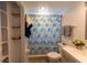 Bathroom with white vanity, shower with colorful curtain, and built-in shelving at 4639 Sloan Ave, Sarasota, FL 34233