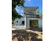 Two-story home featuring an elevated balcony and a ground-level patio, enhanced by natural lighting at 4639 Sloan Ave, Sarasota, FL 34233