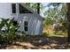Side view of the house with a chimney, foliage, and fenced in area at 4639 Sloan Ave, Sarasota, FL 34233