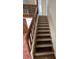 View of stairs with wooden banister leading to upper level and decorative lattice at 4639 Sloan Ave, Sarasota, FL 34233