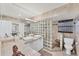 Modern bathroom featuring double sinks, travertine counters and a glass block shower at 501 Sloop Ln, Longboat Key, FL 34228