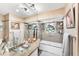 Charming bathroom features custom tilework, glass bowl sink, and unique window accents at 501 Sloop Ln, Longboat Key, FL 34228