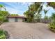 Spacious paved driveway leading to a two-car garage, surrounded by mature trees and lush greenery at 501 Sloop Ln, Longboat Key, FL 34228