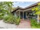 Charming home featuring lush landscaping, a brick walkway, and a welcoming covered front porch at 501 Sloop Ln, Longboat Key, FL 34228