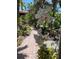 View of the lush landscaping and tiled brick walkway with vibrant white orchids on display near the home at 501 Sloop Ln, Longboat Key, FL 34228
