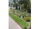 Beautiful and colorful landscaping with vibrant flowers alongside the sidewalk near the lush, tropical home at 501 Sloop Ln, Longboat Key, FL 34228