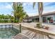 Exterior view of the patio featuring outdoor seating and the backyard with a dock along the waterfront at 501 Sloop Ln, Longboat Key, FL 34228