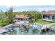 Aerial shot of the rear exterior featuring a dock and patio with outdoor seating and tropical landscaping at 501 Sloop Ln, Longboat Key, FL 34228