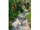 Shaded brick walkway amid lush tropical landscaping that leads up to the quaint home at 501 Sloop Ln, Longboat Key, FL 34228