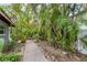 Lush tropical landscaping surrounds a brick walkway leading to the home at 501 Sloop Ln, Longboat Key, FL 34228