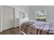 Comfortable bedroom with natural light, light wood floors, closet and large window at 5122 Northridge Rd # 112, Sarasota, FL 34238