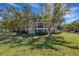 Exterior view of building surrounded by mature trees and lush green grass at 5122 Northridge Rd # 112, Sarasota, FL 34238