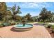 Water fountain in front of a building with lush landscaping, trees, and brick pavers at 5122 Northridge Rd # 112, Sarasota, FL 34238