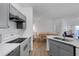 Open kitchen with gray cabinets, white countertops, and a view of the dining and living areas at 5122 Northridge Rd # 112, Sarasota, FL 34238
