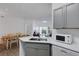Bright kitchen with gray cabinets, white countertops, and stainless steel appliances, open to the dining area at 5122 Northridge Rd # 112, Sarasota, FL 34238