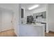 Kitchen featuring an open layout, counter with sink, gray appliances and light wood flooring at 5122 Northridge Rd # 112, Sarasota, FL 34238