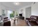 Inviting living room with a leather sofa, sliding glass doors to the patio, and a TV at 5122 Northridge Rd # 112, Sarasota, FL 34238