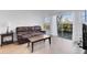 Bright living room featuring a leather sofa, coffee table, and sliding glass doors to the outside patio at 5122 Northridge Rd # 112, Sarasota, FL 34238