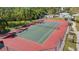 An aerial view of the tennis court with its net and surrounding green landscape at 5122 Northridge Rd # 112, Sarasota, FL 34238