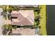 Aerial view showing a tile roof and the lush green lawn alongside a picturesque lake at 5509 Avellino Pl, Sarasota, FL 34238