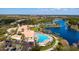 Aerial view showcasing lake, community pool, clubhouse, and tennis courts at 5509 Avellino Pl, Sarasota, FL 34238