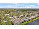 Aerial view of a residential community with tile roofs, lush landscaping and a lake at 5509 Avellino Pl, Sarasota, FL 34238