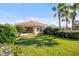 Well-maintained backyard features a screened lanai, lush lawn, and mature tropical landscaping at 5509 Avellino Pl, Sarasota, FL 34238