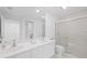 Clean, bright bathroom with double sinks, a large mirror, and a glass-enclosed shower at 5509 Avellino Pl, Sarasota, FL 34238
