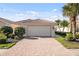 Charming home exterior featuring a brick driveway, two car garage, lush landscaping, and tile roof at 5509 Avellino Pl, Sarasota, FL 34238