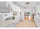 Spacious kitchen with white cabinetry, neutral backsplash, and seamless flow to dining area at 5509 Avellino Pl, Sarasota, FL 34238