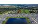 Aerial view of houses lining a pond with a green space area in the Creek Preserve community at 5547 Logan Cave Ave, Wimauma, FL 33598
