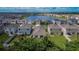 Aerial view of a neighborhood featuring a scenic lake and well-maintained homes with green lawns at 5547 Logan Cave Ave, Wimauma, FL 33598