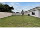 Fenced backyard featuring lush green grass providing a secure and private outdoor space at 5547 Logan Cave Ave, Wimauma, FL 33598