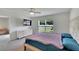 Bright bedroom with a wall-mounted TV and backyard view through a large window at 5547 Logan Cave Ave, Wimauma, FL 33598