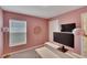 Bright pink bedroom featuring a modern desk and contemporary lighting fixtures creating a vibrant atmosphere at 5547 Logan Cave Ave, Wimauma, FL 33598