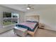 Bright bedroom with patterned headboard, plush blanket, and view of landscaped backyard at 5547 Logan Cave Ave, Wimauma, FL 33598